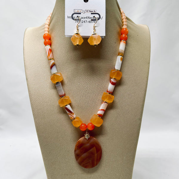 Necklace and earrings set on a mannequin bust with a visible brand tag.