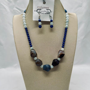 Beaded necklace and earrings set on a mannequin bust with a visible brand tag.