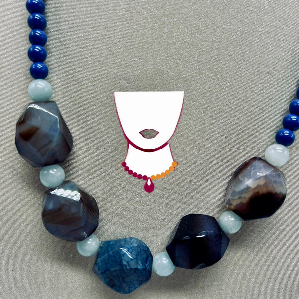 Necklace with blue and gray beads on a gray background