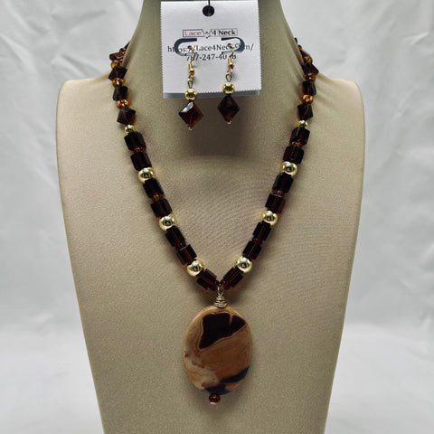 Necklace and earring set on a mannequin bust with a visible brand tag.