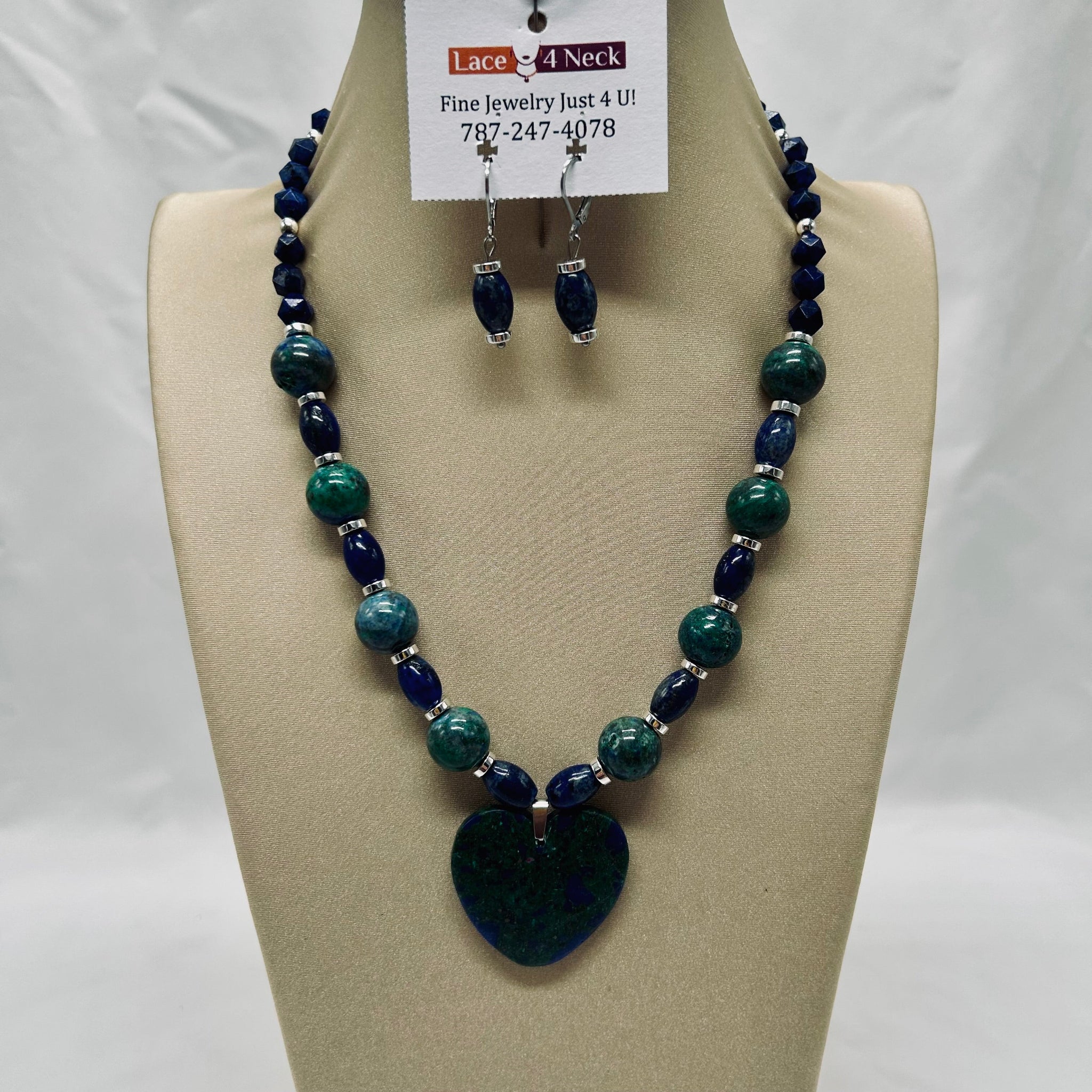Necklace and earrings set on a mannequin bust with a visible brand tag.