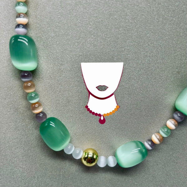 A beaded necklace with large translucent green beads, smaller multicolored beads, and a shiny gold accent bead, displayed on a textured gray background with a white necklace graphic overlay.