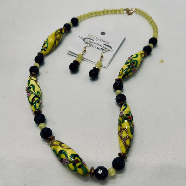 Jewelry set with yellow beaded necklace and earrings on a white background