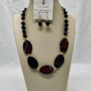 Necklace and earrings set on a mannequin bust with a visible brand tag.
