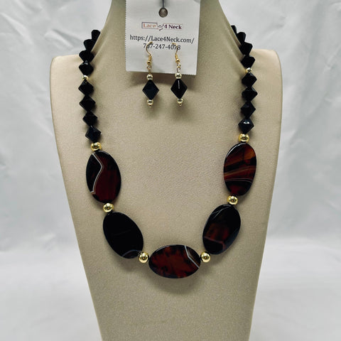 Necklace and earrings set on a mannequin bust with a visible brand tag.