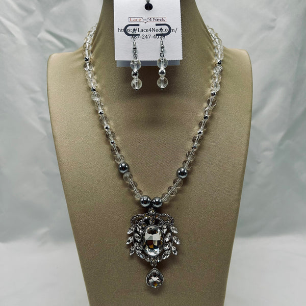Necklace and earrings set on a mannequin bust with a visible brand tag.