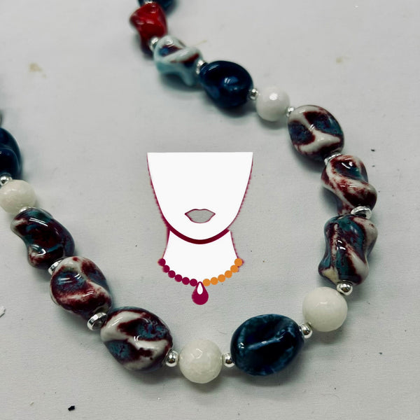 Necklace with marbled beads on a white background with a small illustration of a face.