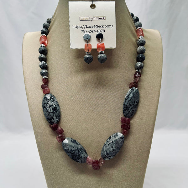 Necklace and earrings set on a mannequin with a visible brand tag.