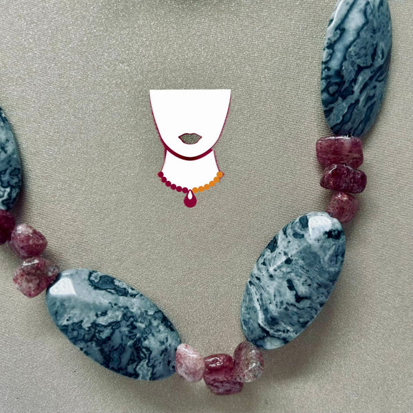 Necklace with blue and pink beads on a beige fabric background