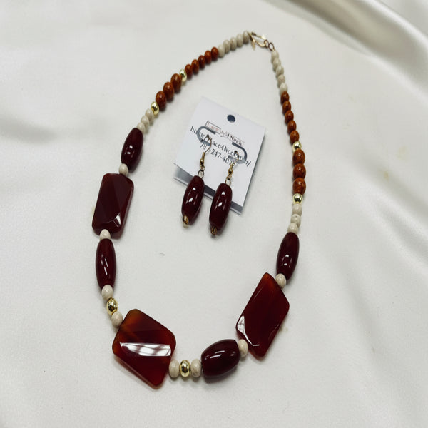 Necklace and earrings set with brown and white beads on a white background