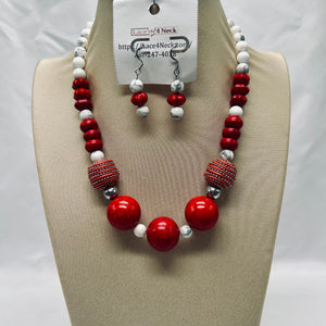 Necklace and earrings set with red, white, and silver beads on a mannequin bust.