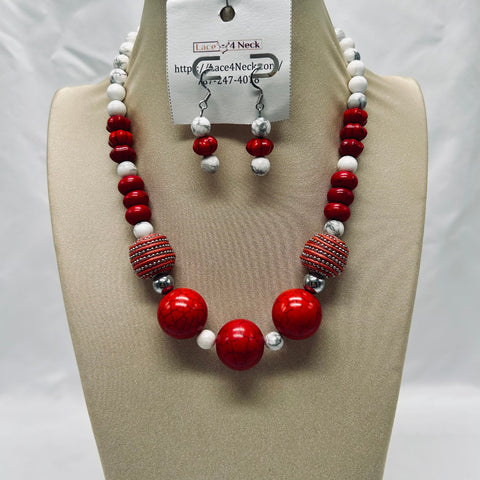 Necklace and earrings set with red, white, and silver beads on a mannequin bust.