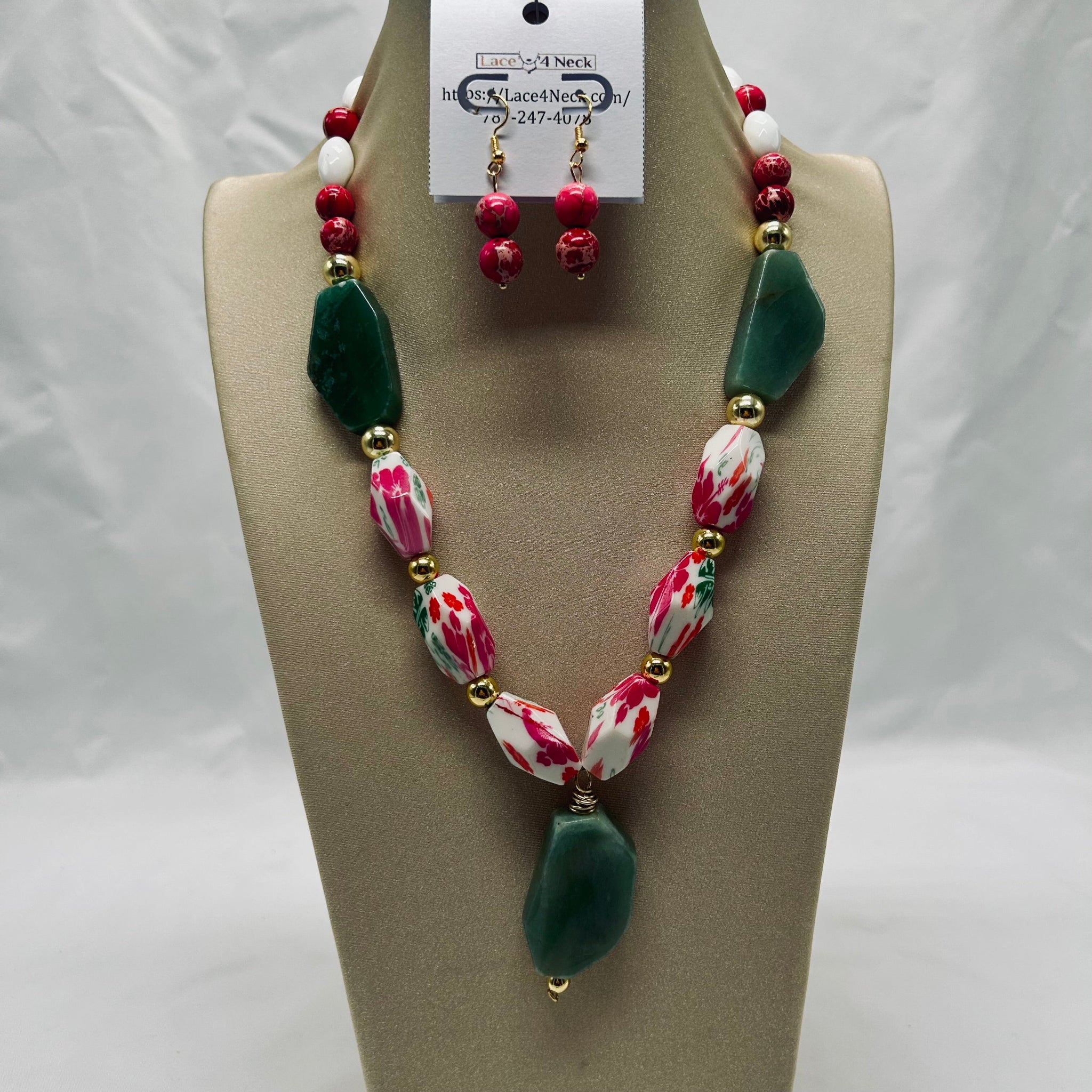 Necklace and earrings set on a mannequin bust with a visible brand tag.