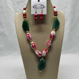 Necklace and earrings set on a mannequin bust with a visible brand tag.