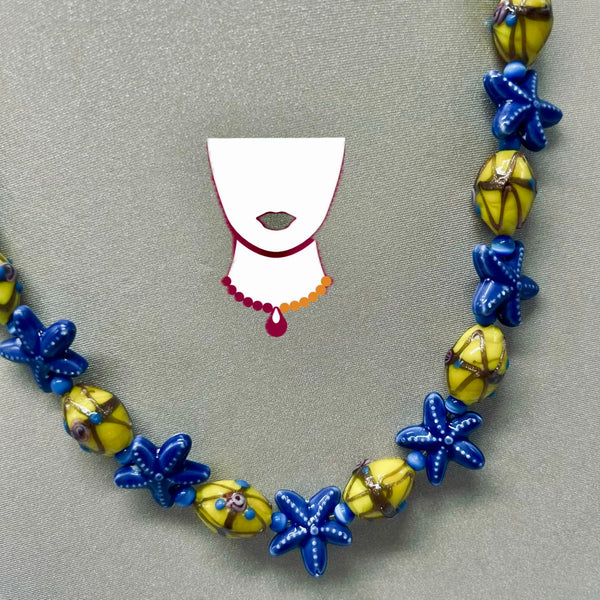 Necklace with blue and yellow star-shaped beads on a gray background