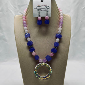 Beaded necklace and earrings set on a mannequin bust with a visible brand tag.