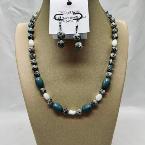 Beaded necklace and earrings set on a mannequin bust with a visible brand tag.