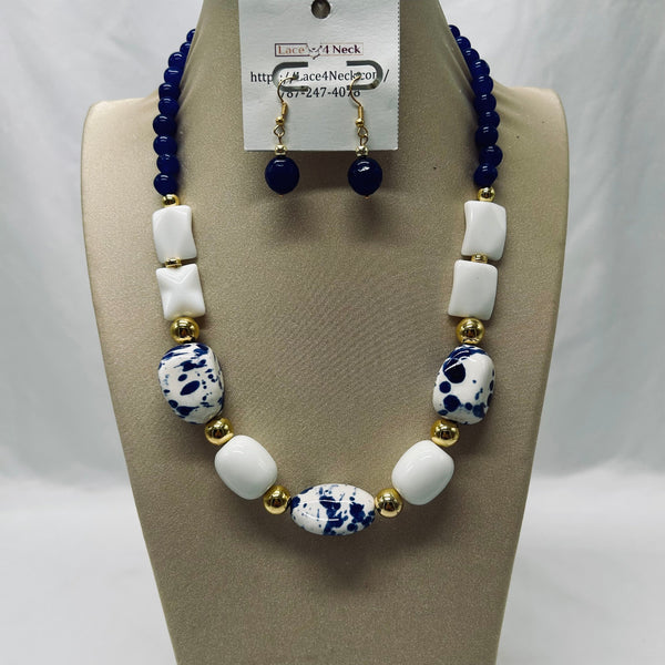 Necklace with blue, white, and gold beads on a mannequin bust with a visible brand tag.