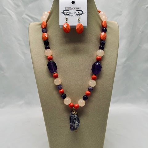 Necklace and earrings set on a display stand with a card behind it.