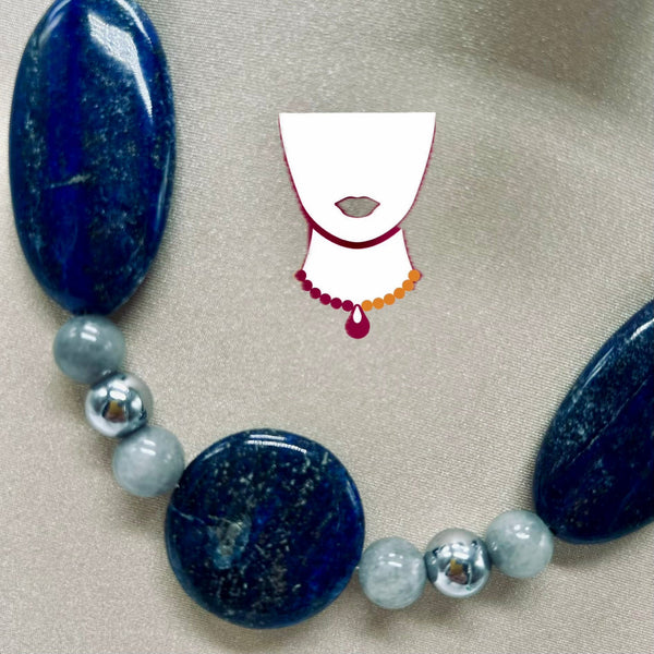 Necklace with blue and gray beads on a beige background
