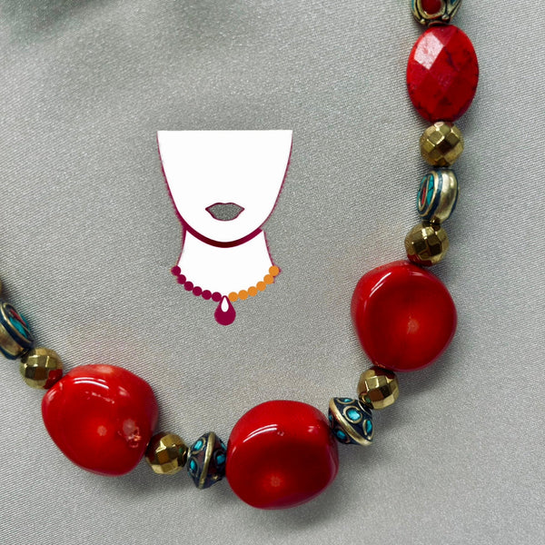 Necklace with red beads and gold accents on a gray background