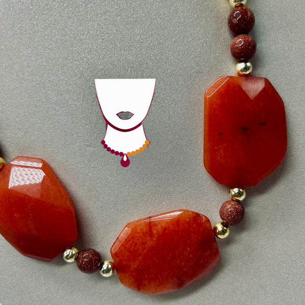 Necklace with red beads on a gray background