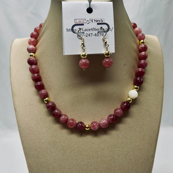 Necklace and earrings set on a mannequin bust with a visible brand tag.