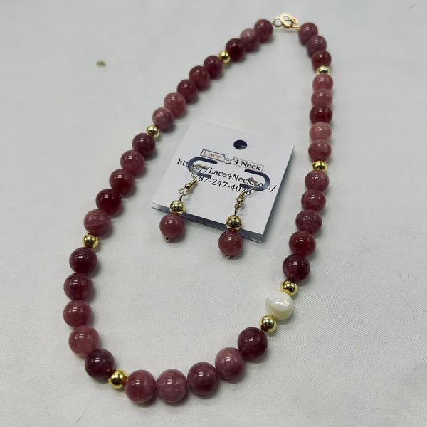 Necklace with pink beads and gold accents on a white background