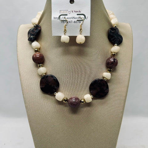 Necklace and earrings set on a mannequin bust with a visible brand tag.