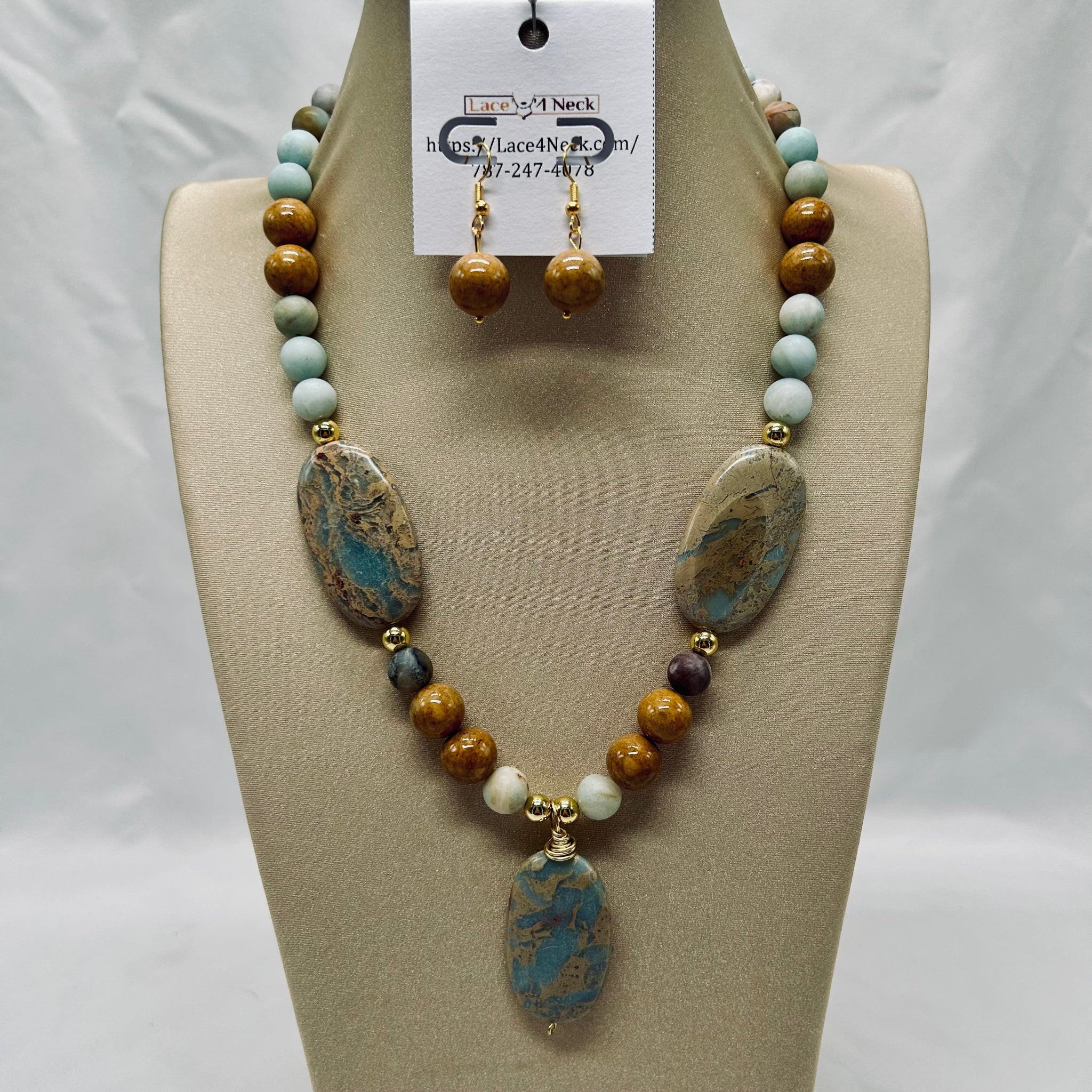 Necklace and earrings set on a mannequin bust with a visible brand tag.