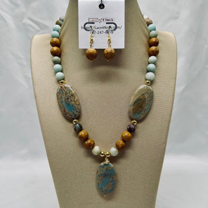 Necklace and earrings set on a mannequin bust with a visible brand tag.