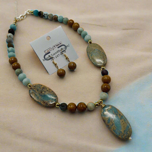 Necklace with stone beads and matching earrings on a white background