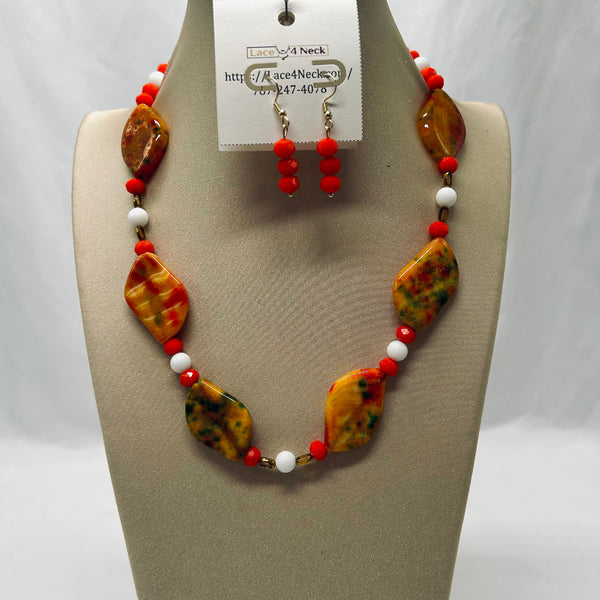 Necklace and earrings set on a mannequin with a visible brand tag.