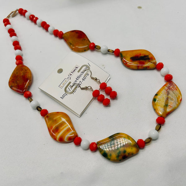 Necklace with amber-colored beads and red accents on a white background