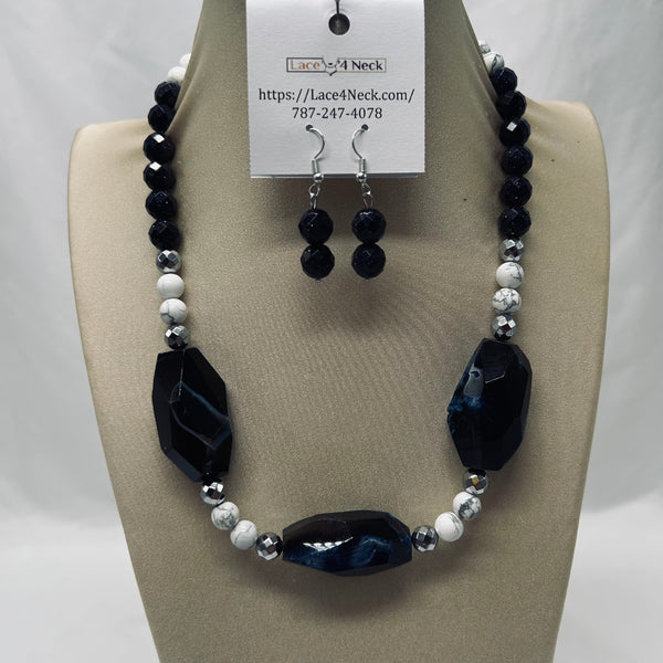 Necklace and earrings set on a mannequin with a visible brand tag.