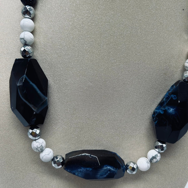 Necklace with black and white beads on a gray background