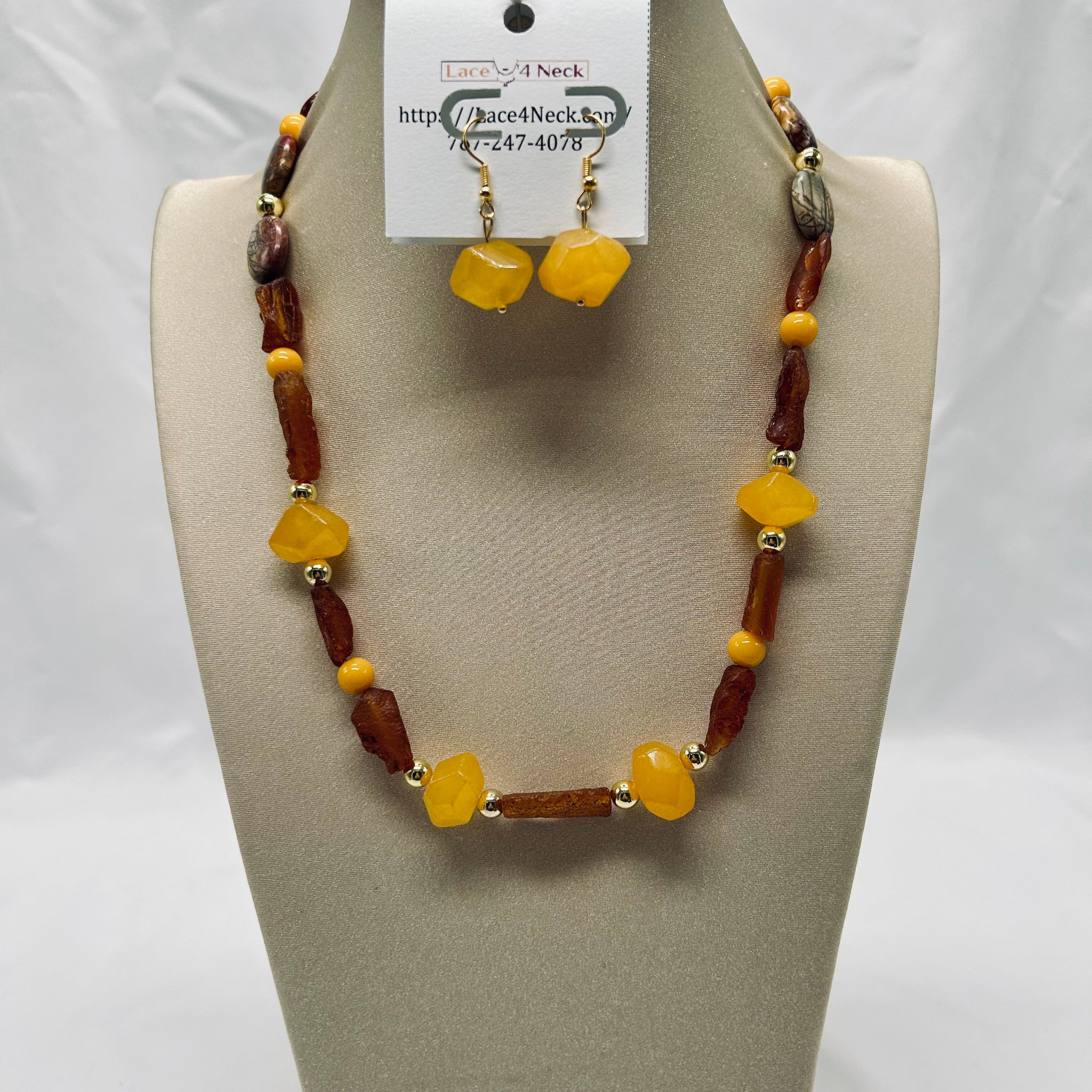 Necklace and earrings set on a mannequin bust with a visible brand tag.