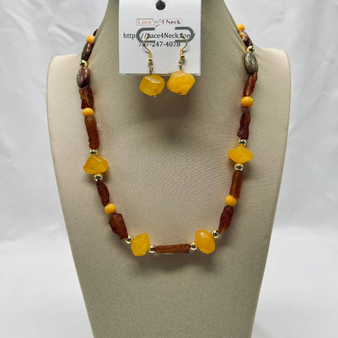 Necklace and earrings set on a mannequin bust with a visible brand tag.