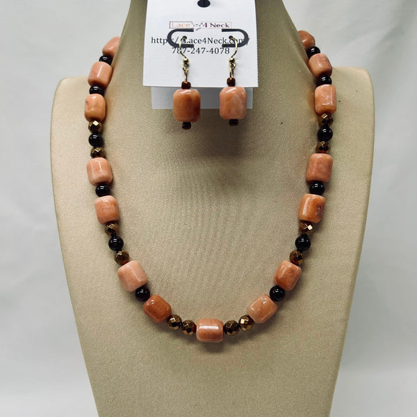 Necklace and earrings set on a beige display with a tag.