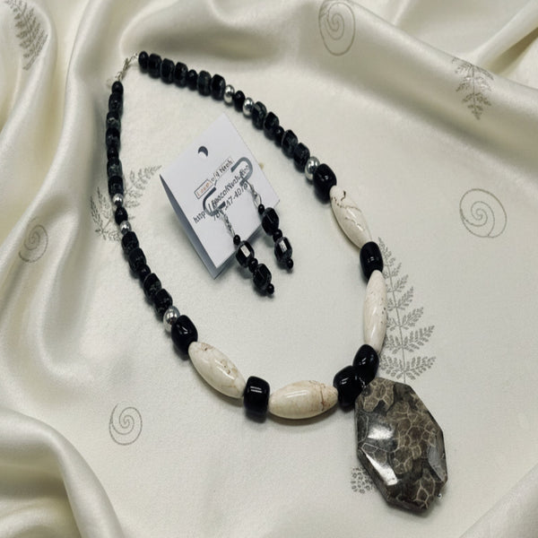 Necklace with black and white beads on a gray background