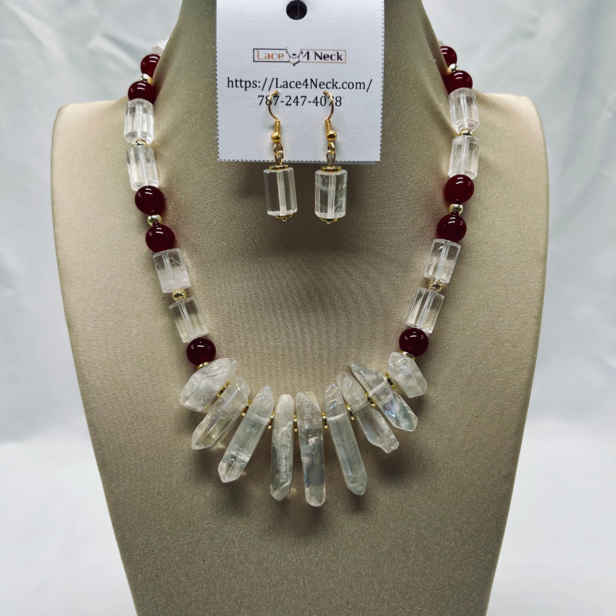 Necklace and earrings set on a mannequin bust with a visible brand card.