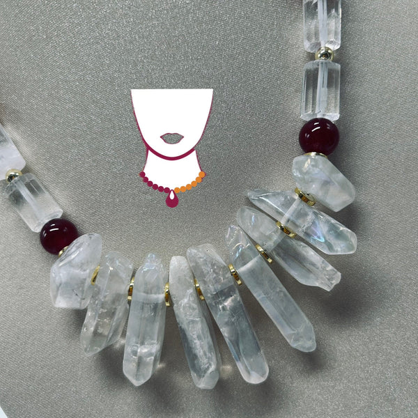 Necklace with clear crystal beads and red beads on a gray background