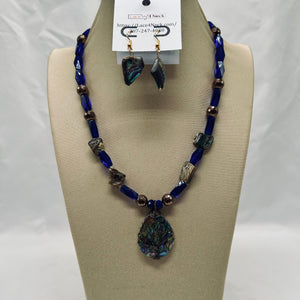 Jewelry set with blue beaded necklace and earrings on a mannequin bust.