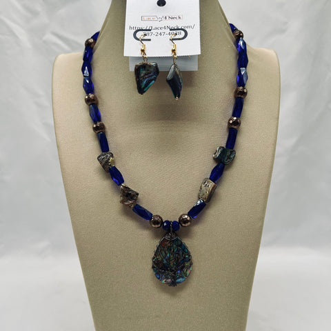 Jewelry set with blue beaded necklace and earrings on a mannequin bust.
