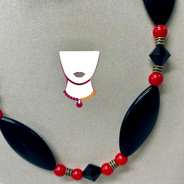 Necklace with black and red beads on a gray background
