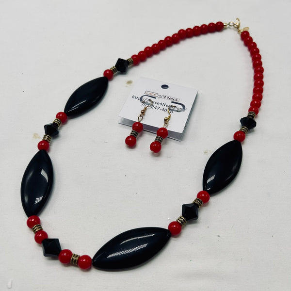 Necklace and earrings set with black and red beads on a white background
