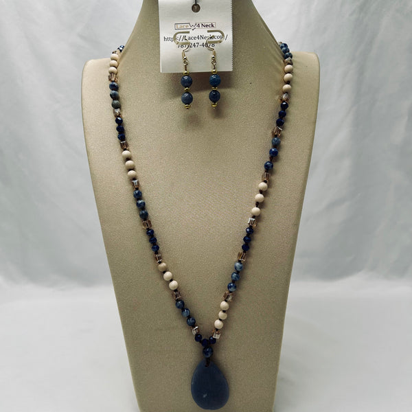 Necklace and earrings set on a mannequin bust with a white background
