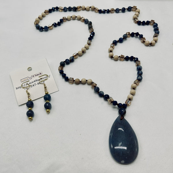 Beaded necklace with a teardrop pendant and matching earrings on a white background.