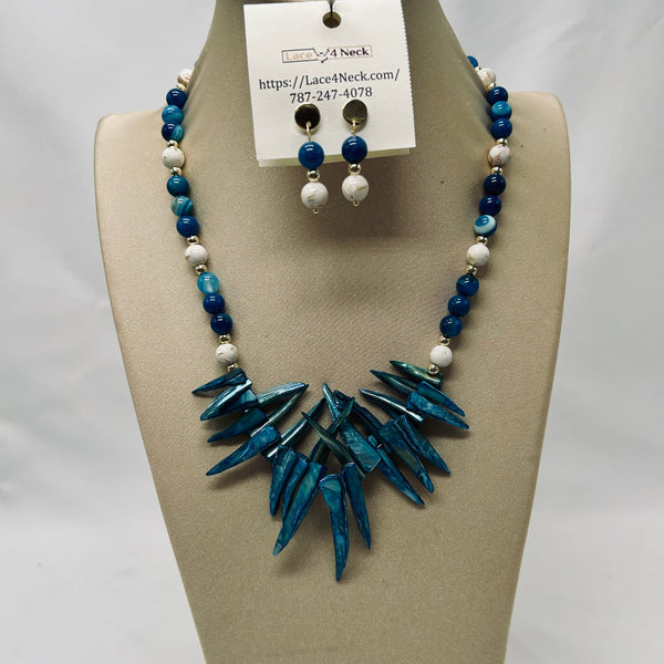 Necklace and earrings set on a mannequin with a visible brand tag.