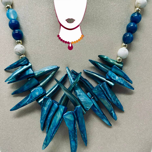 Necklace with blue and white beads on a neutral background